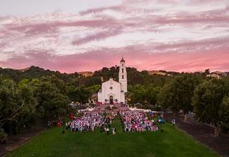 A Saint Mary's College campus event with tables and lights on the chapel lawn